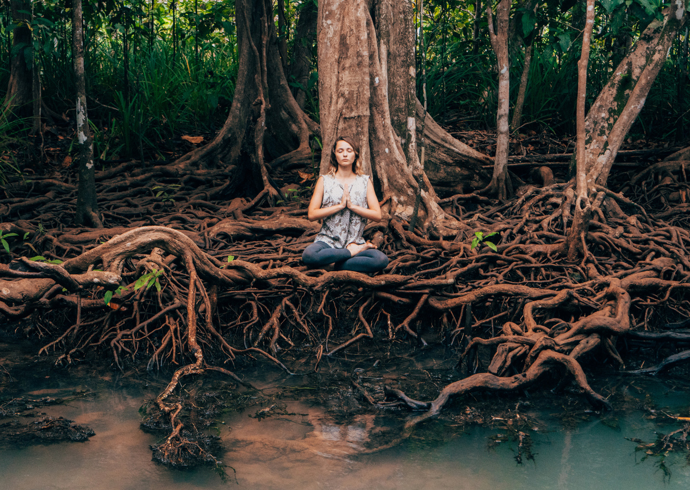 Frau meditiert unter Baum